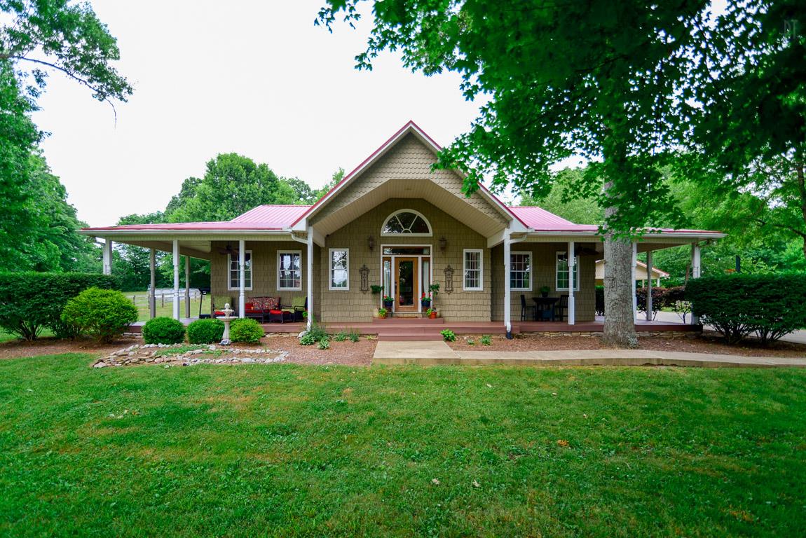 a front view of a house with a yard and trees