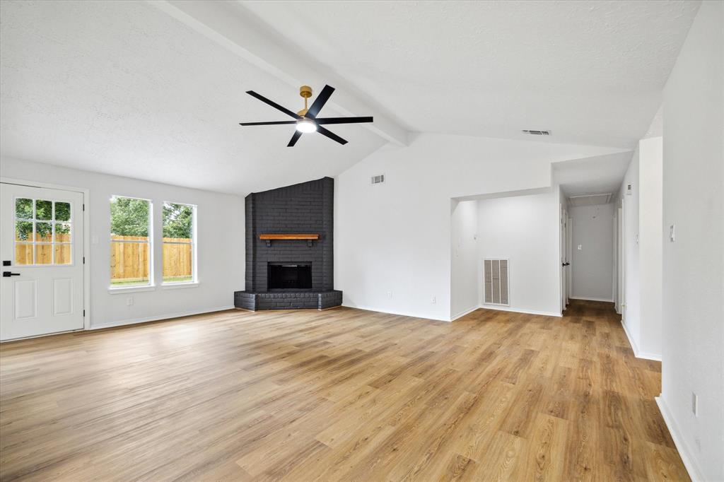 a view of empty room with wooden floor and fireplace