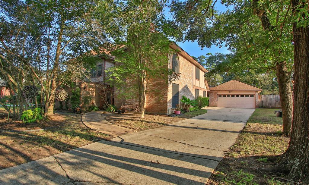 a view of a house with a yard and a large tree