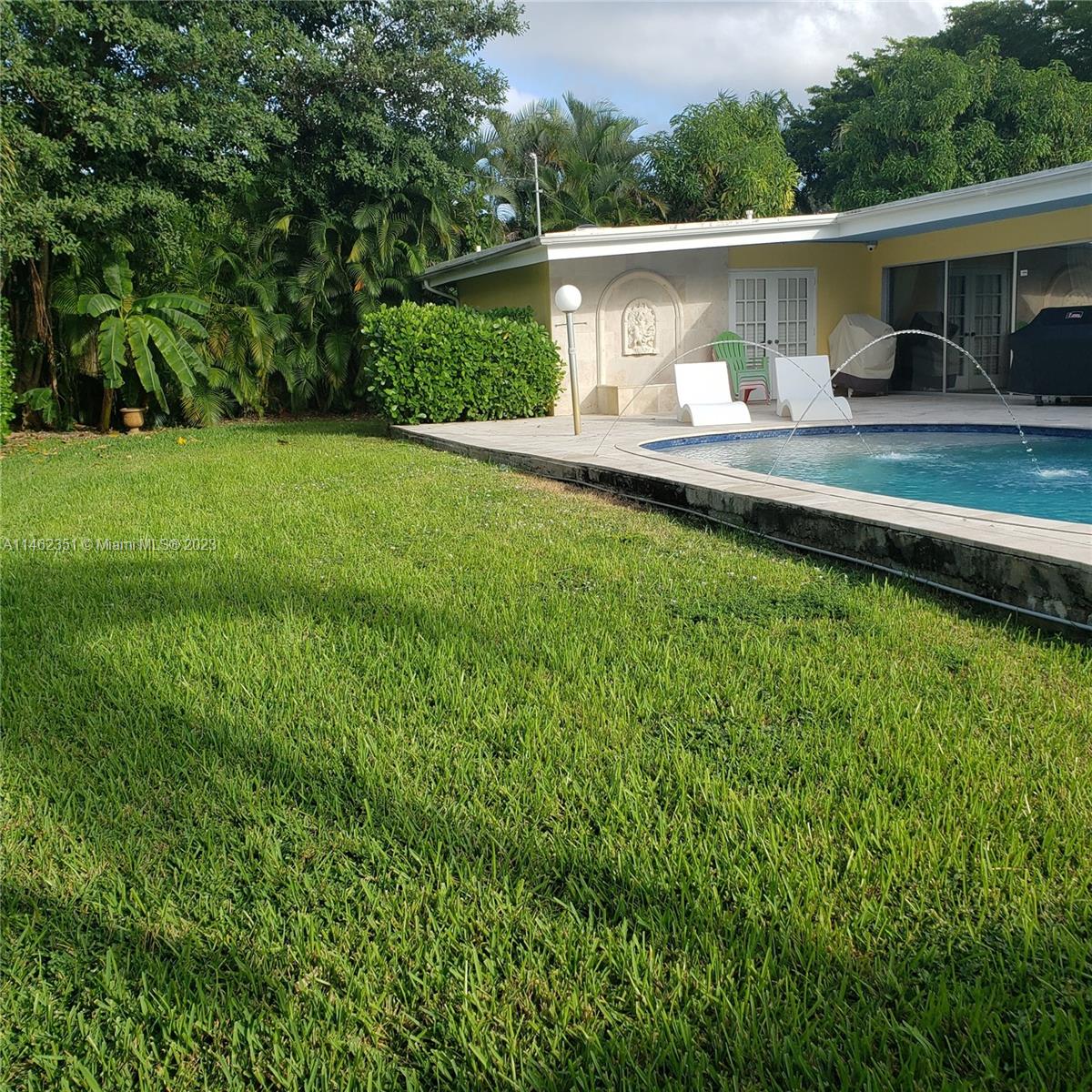 a front view of house with yard and trees in the background