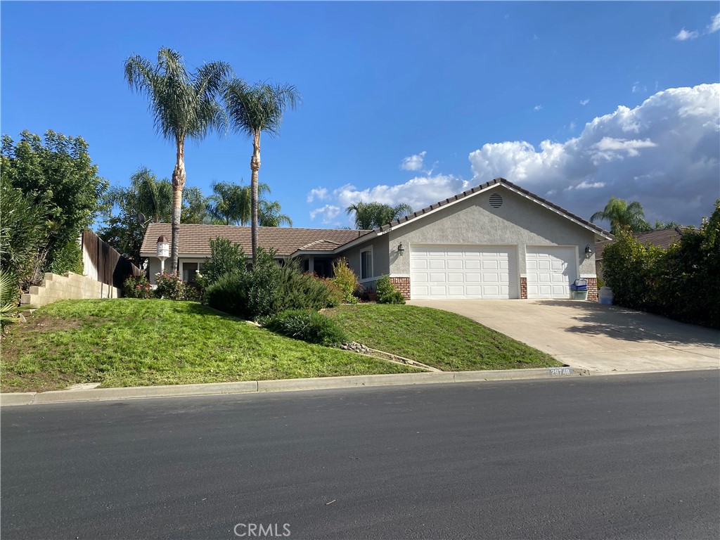 a view of a house with a yard and palm trees