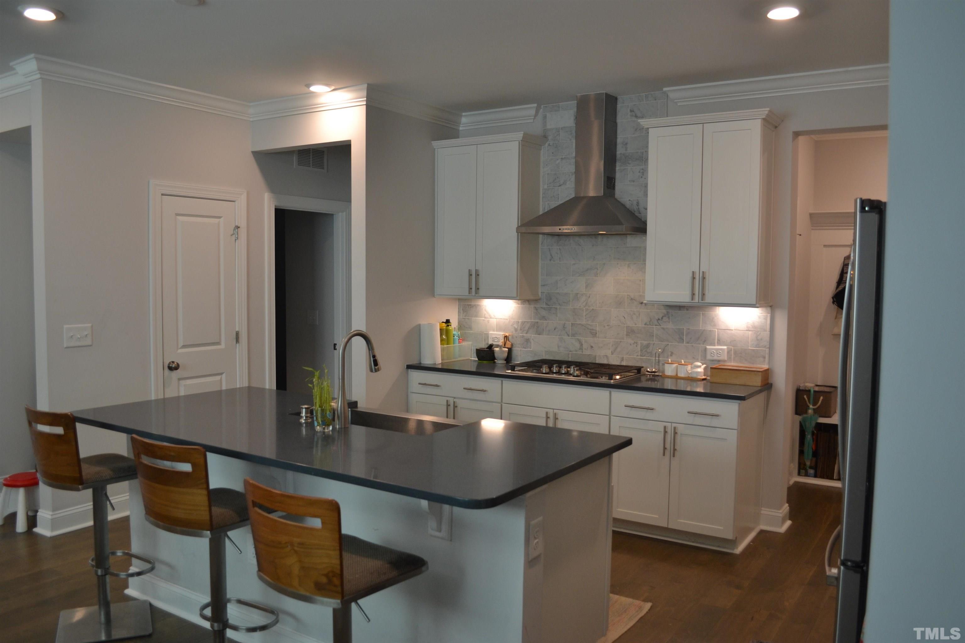 a kitchen with kitchen island granite countertop a sink stainless steel appliances and cabinets