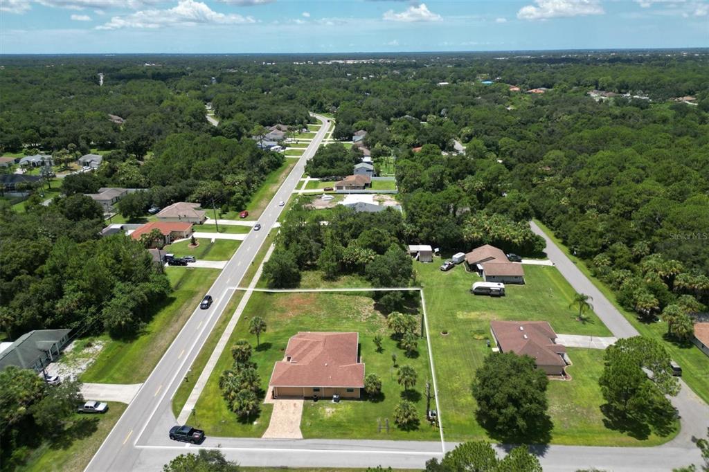 an aerial view of residential houses with outdoor space and street view