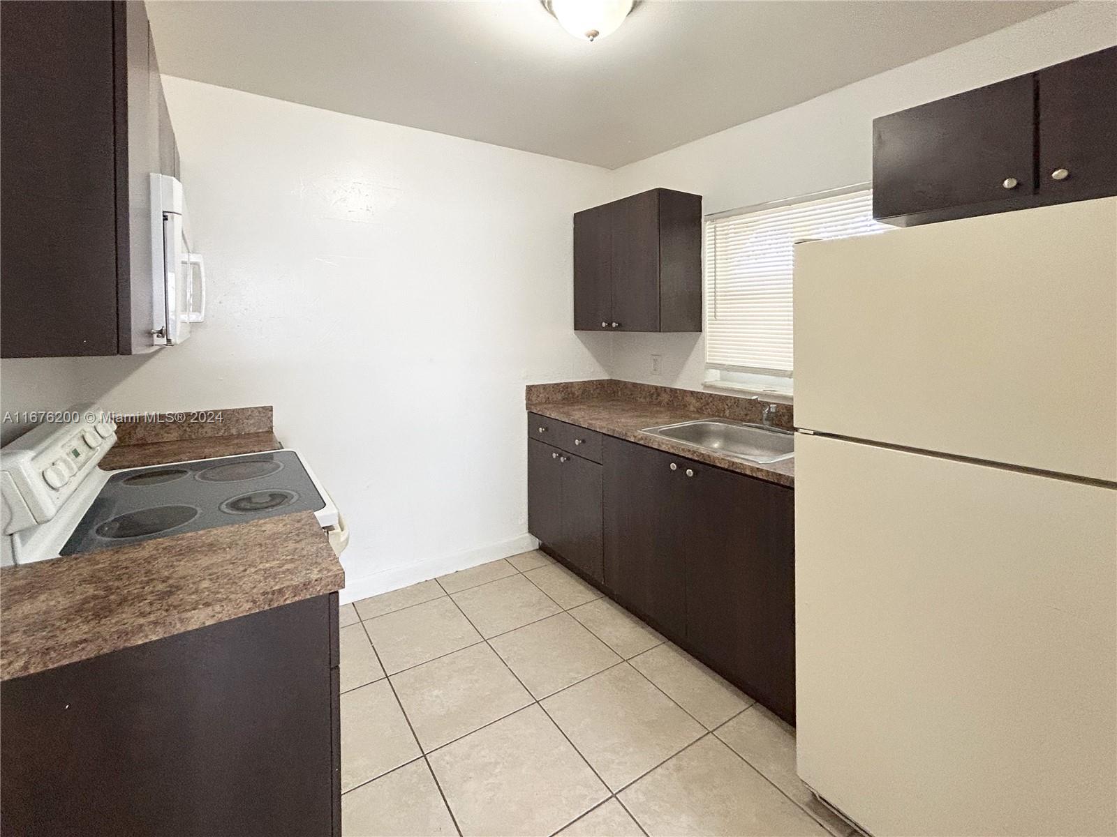 a kitchen with granite countertop a refrigerator and a stove