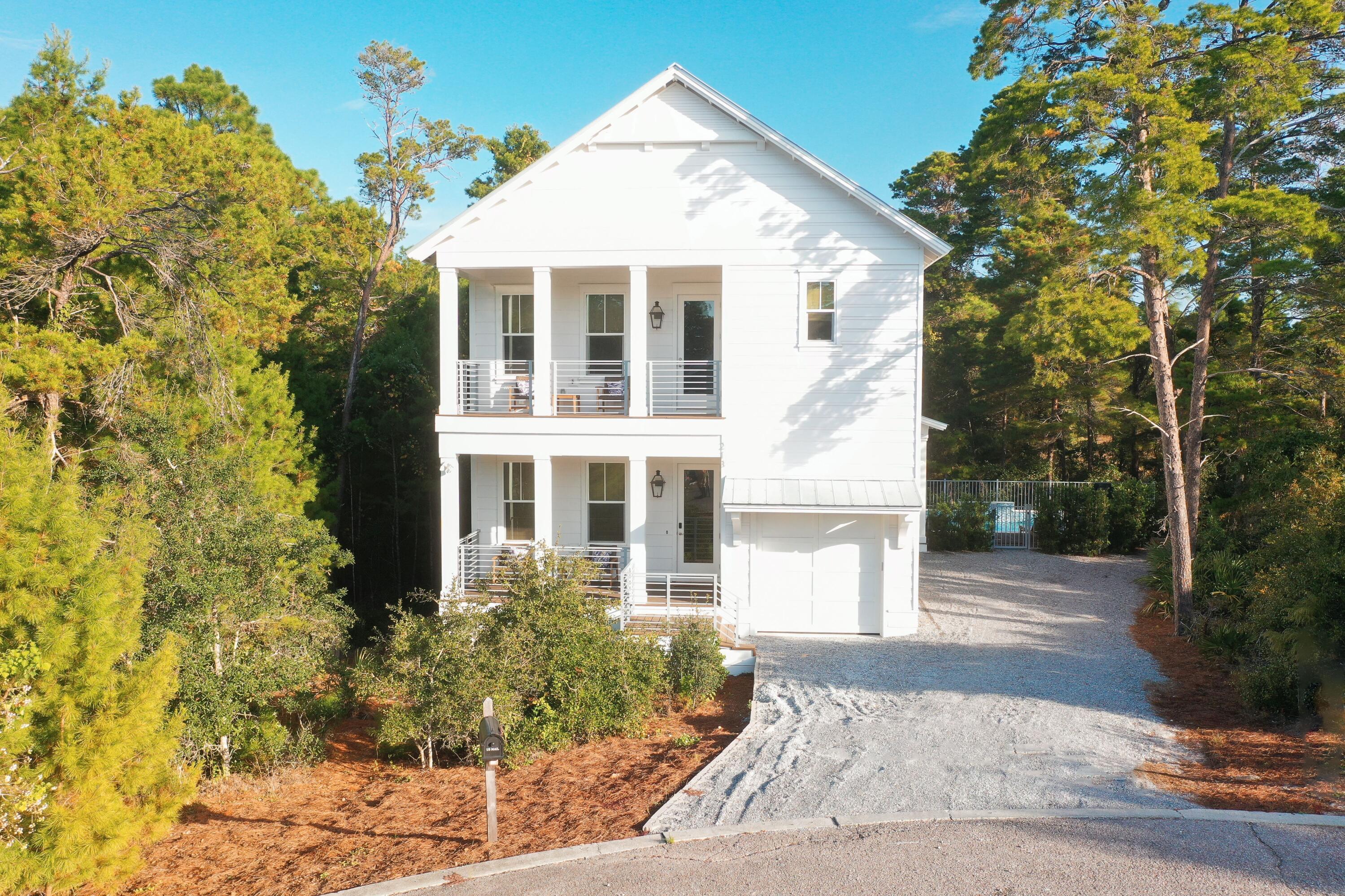 a front view of a house with a yard and trees