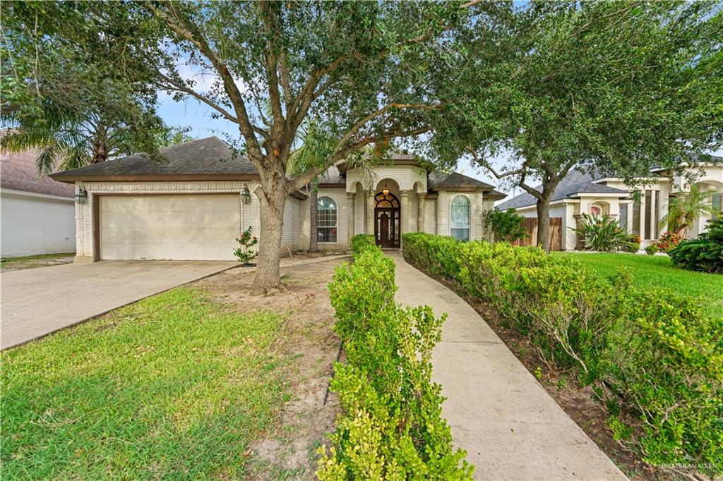 a front view of a house with a yard and trees