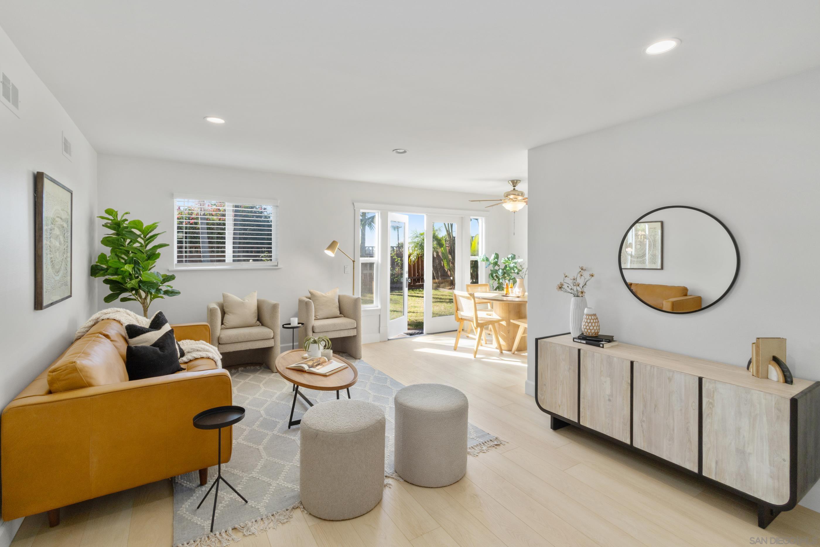 a living room with furniture a mirror a lamp and a large window