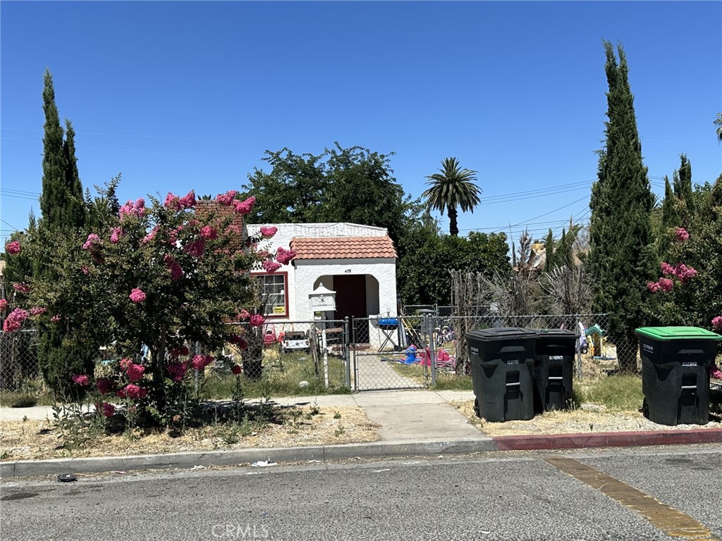 a front view of a house with a yard and tree s