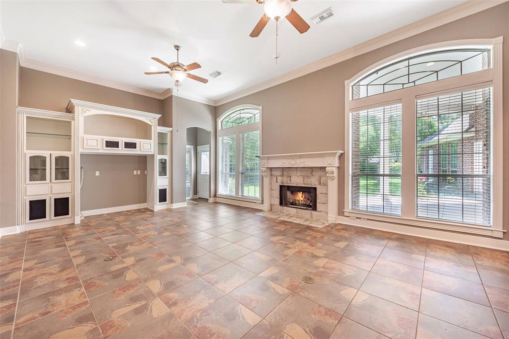 a view of an empty room with a fireplace and a window