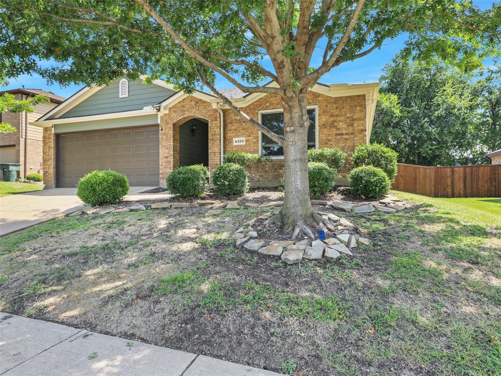 a front view of a house with a yard and potted plants