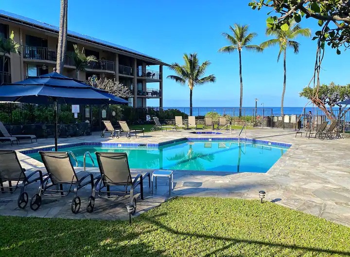 a view of a chairs and table in patio with swimming pool