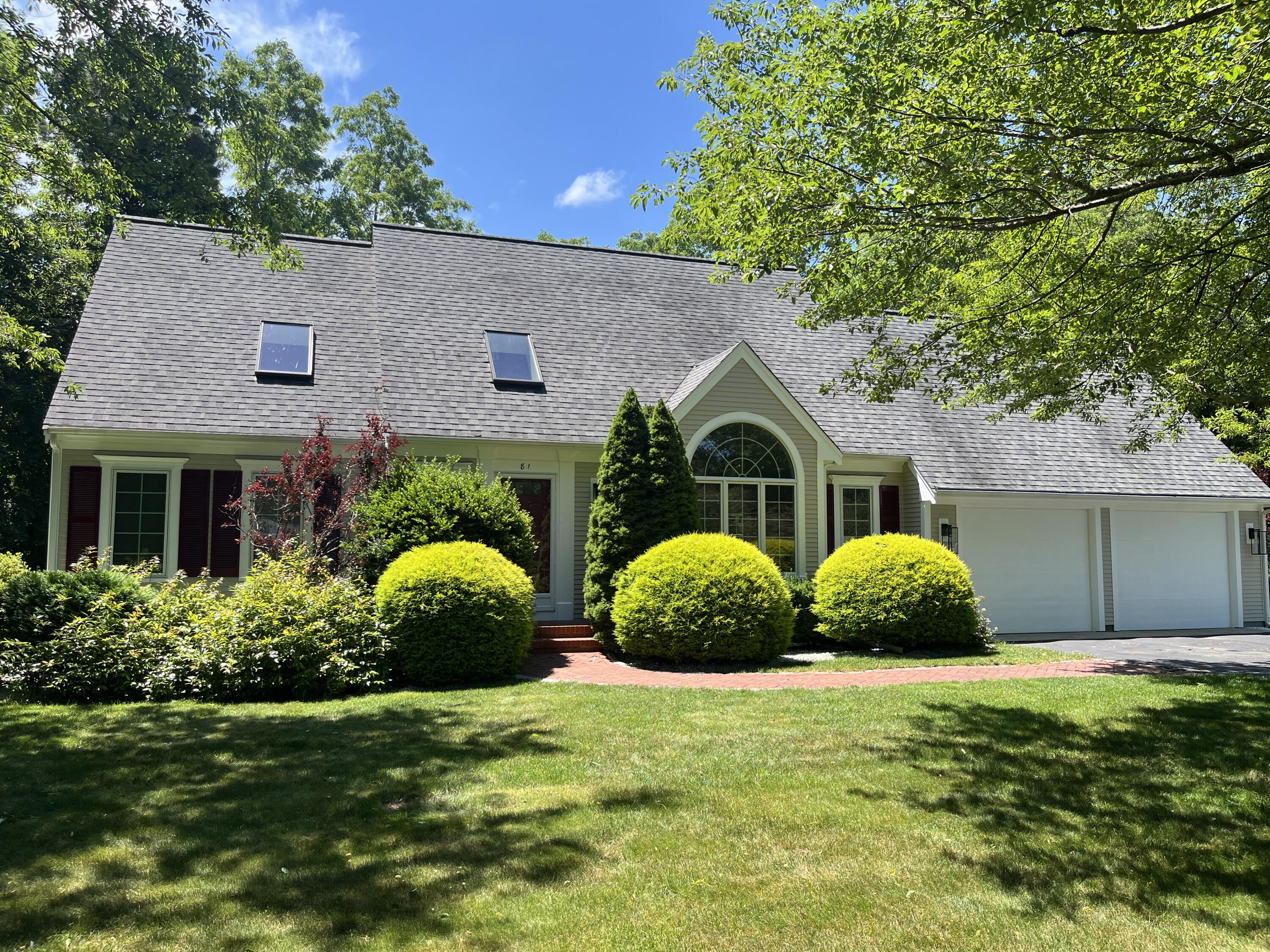 a view of a house with a yard and large tree