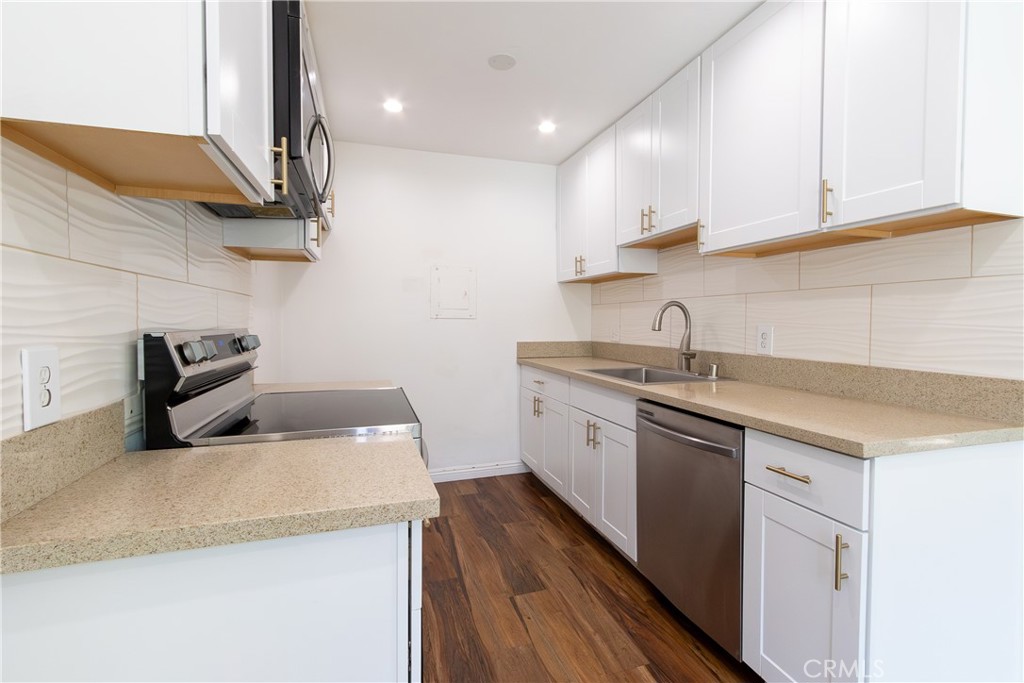 a kitchen with a sink a stove and cabinets