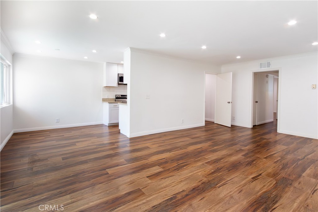 a view of empty room with wooden floor