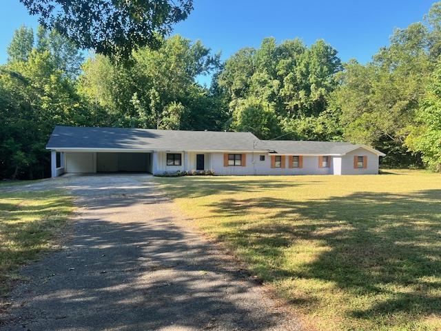 Ranch-style home with a front lawn and a carport