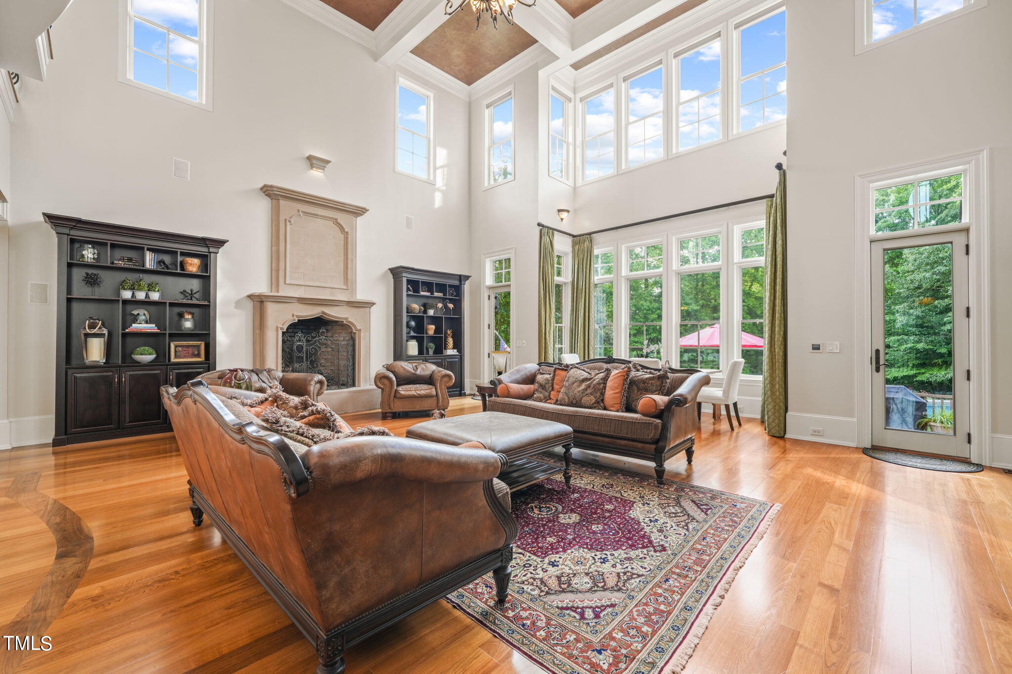 a living room with furniture large window and wooden floor