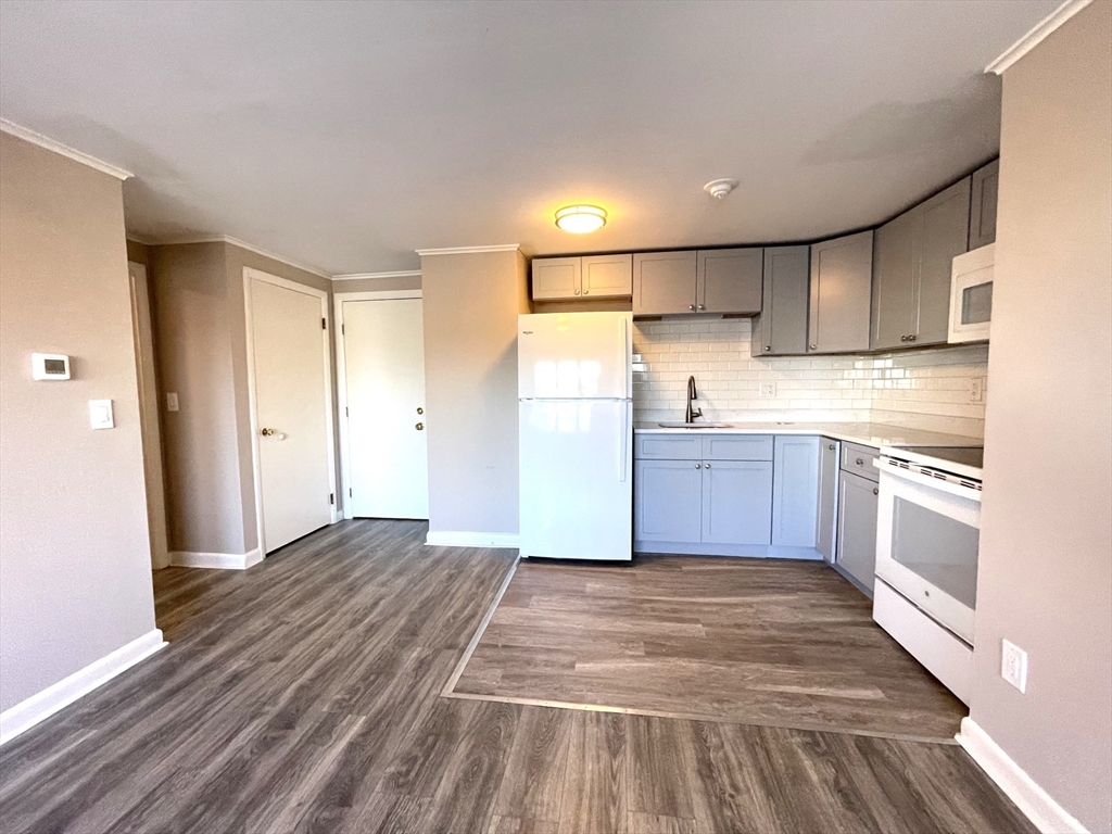 a kitchen with granite countertop a sink cabinets stainless steel appliances and a window