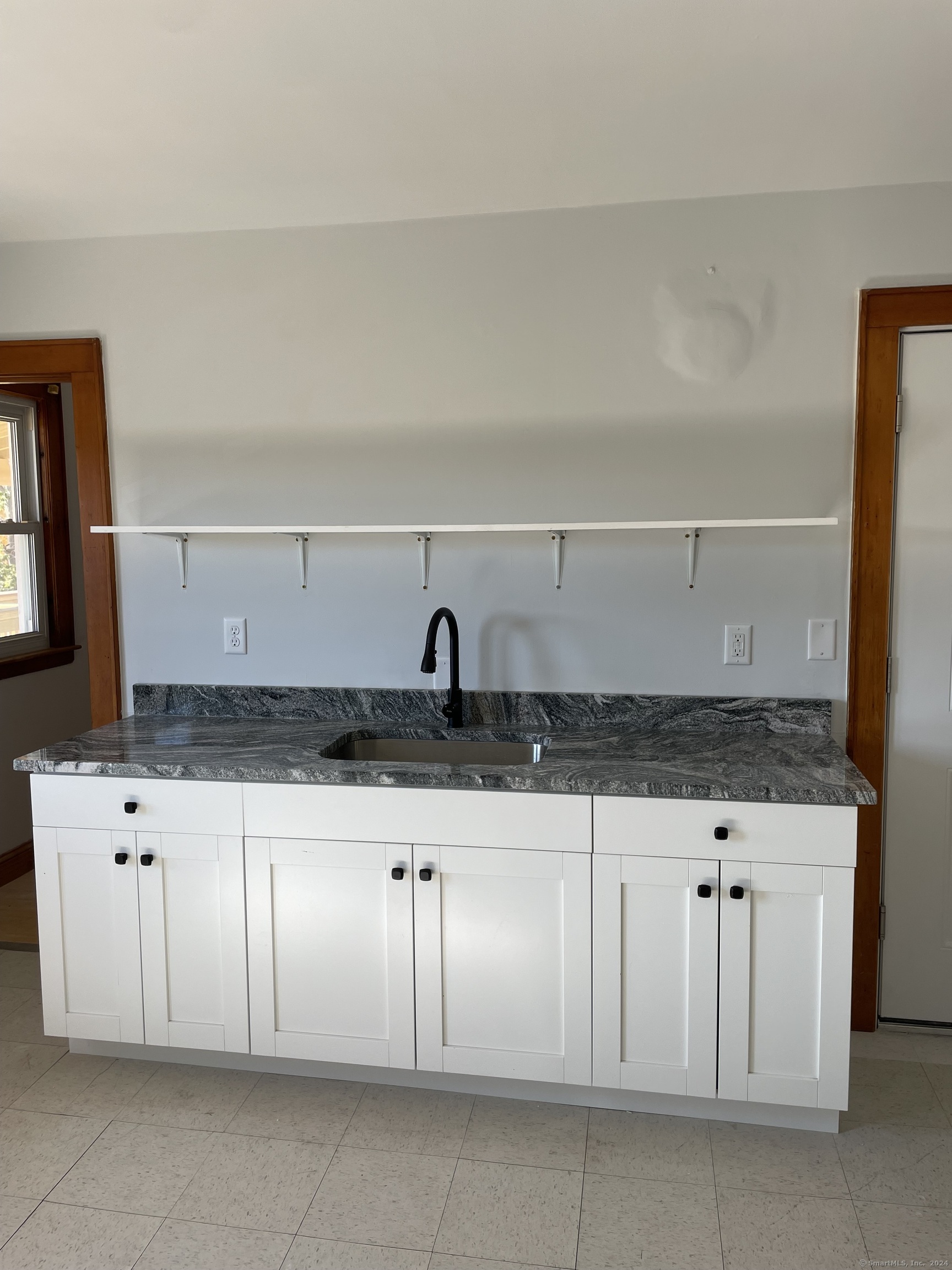 a kitchen with granite countertop white cabinets and sink