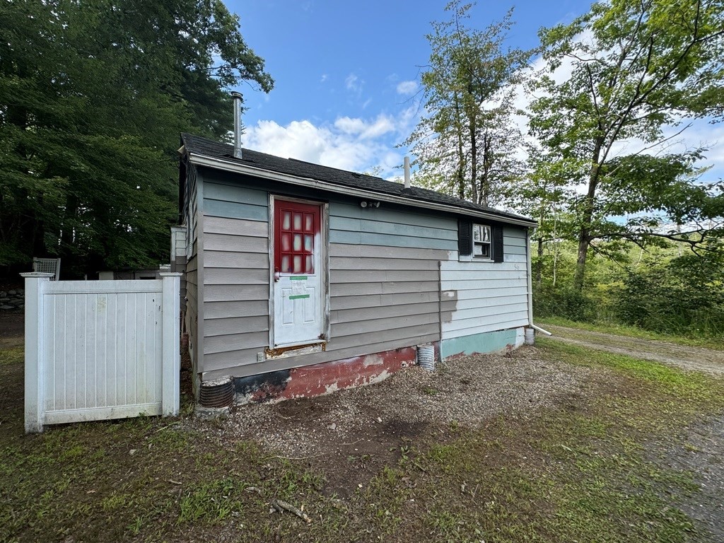 a view of backyard of house with wooden fence