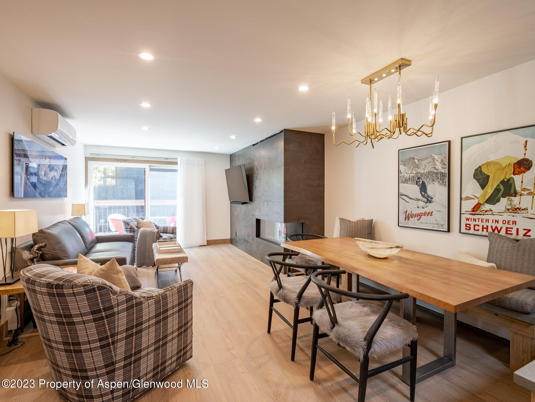 a living room with furniture a chandelier and kitchen view