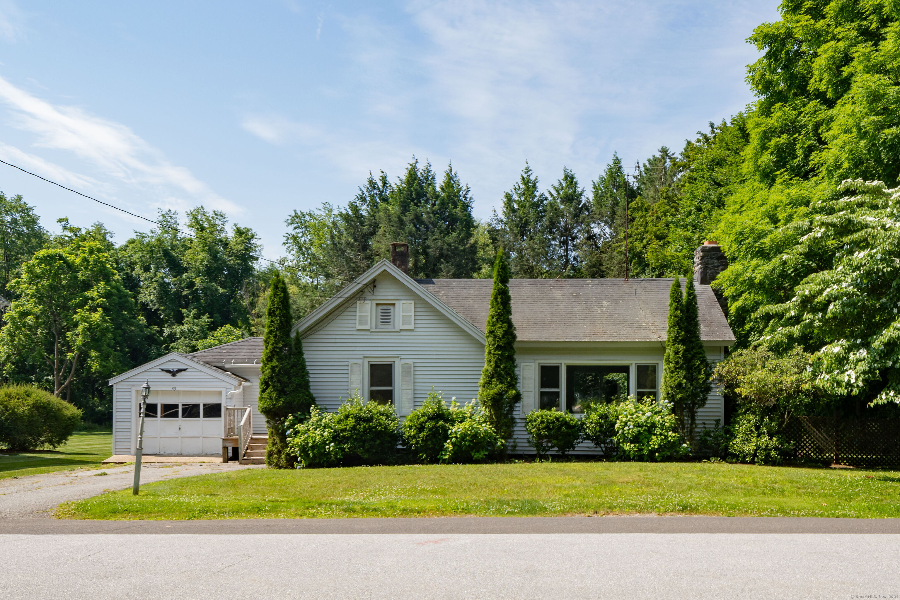 a front view of a house with a garden and yard