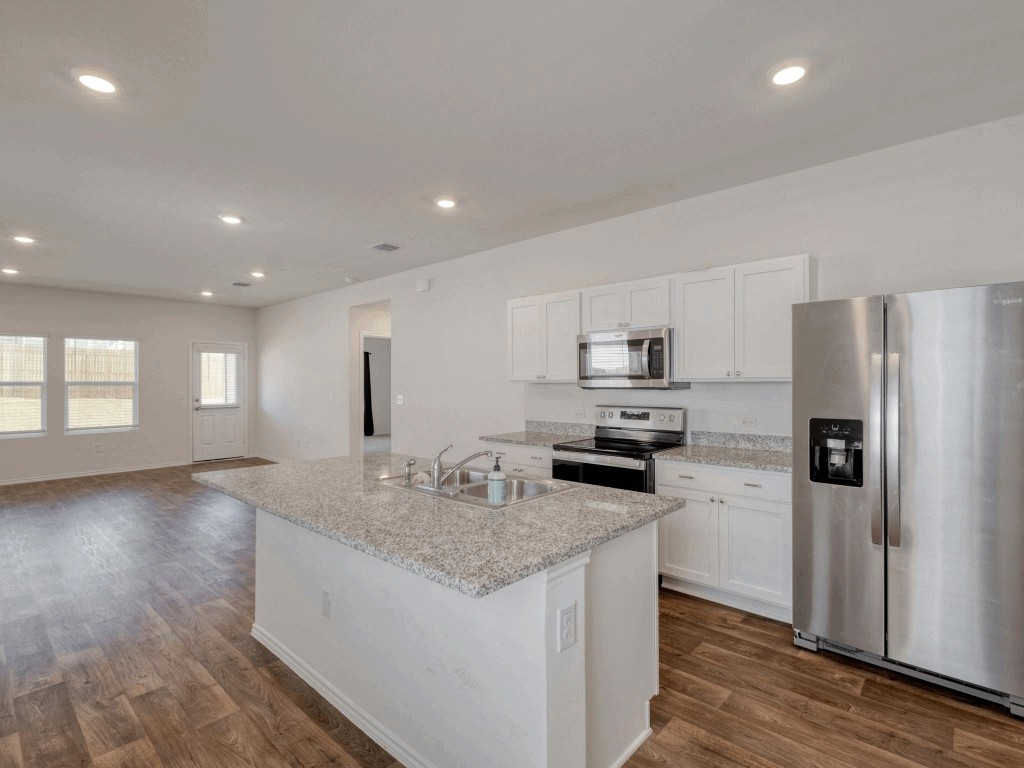 a kitchen with a sink refrigerator and microwave