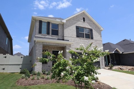 a front view of a house with plants