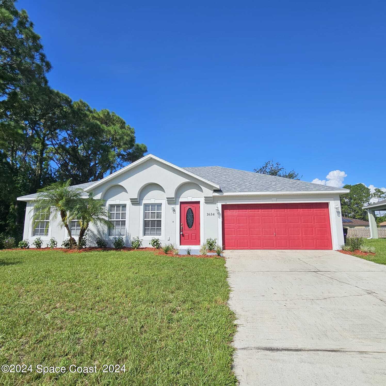 a view of a house with a yard and fence