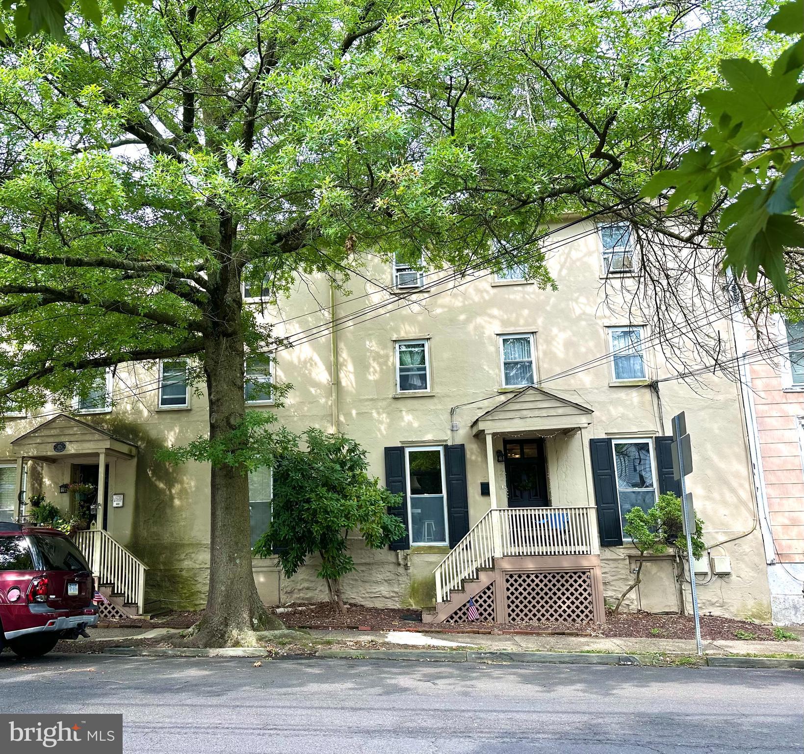 a front view of a house with a tree