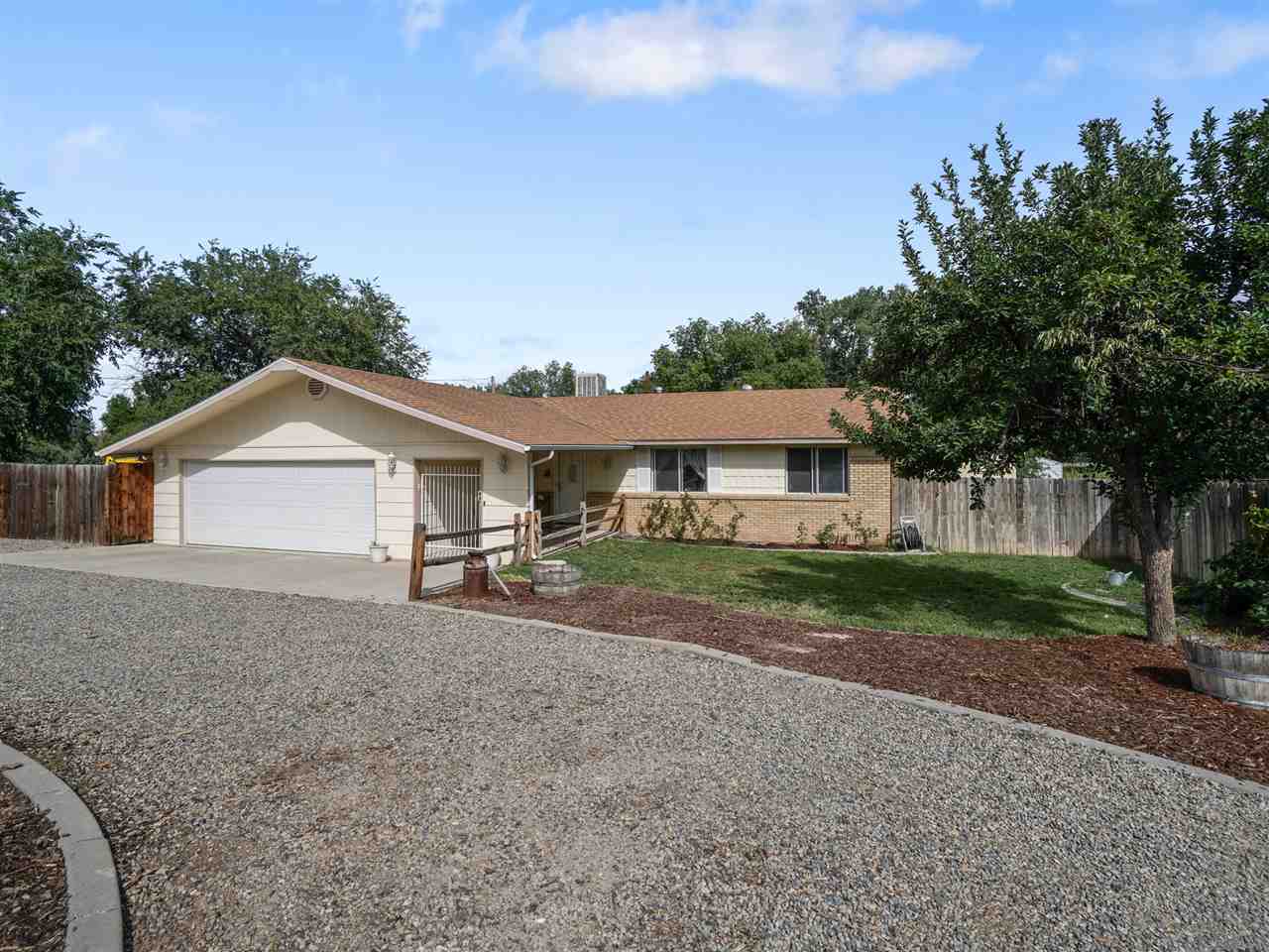 a view of a house with a yard and large trees