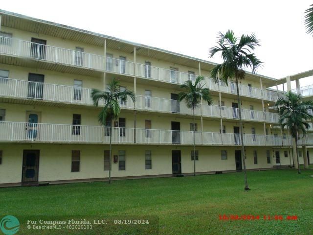 a front view of a building with a garden