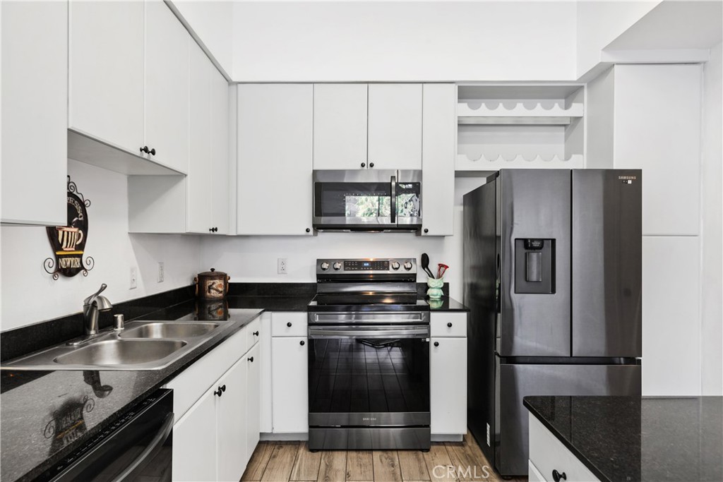 a kitchen with stainless steel appliances a refrigerator a sink and a stove