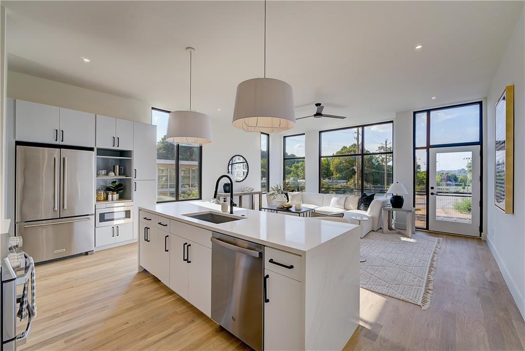 a kitchen with stainless steel appliances granite countertop a sink stove and refrigerator