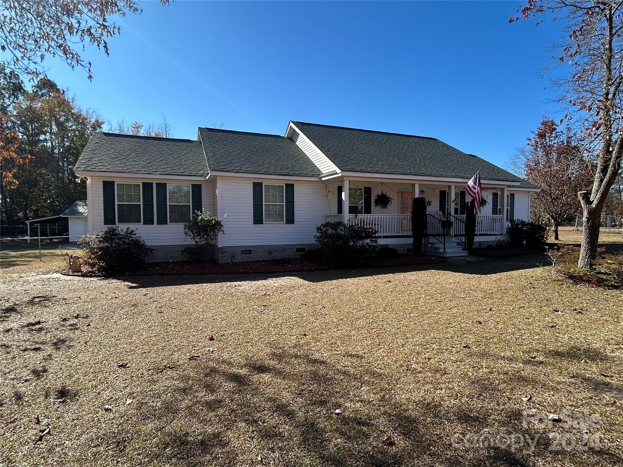 a front view of a house with a yard covered in snow