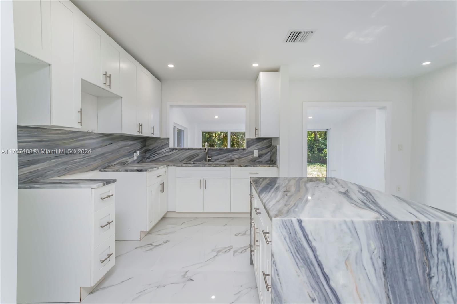 a kitchen with a sink window and cabinets