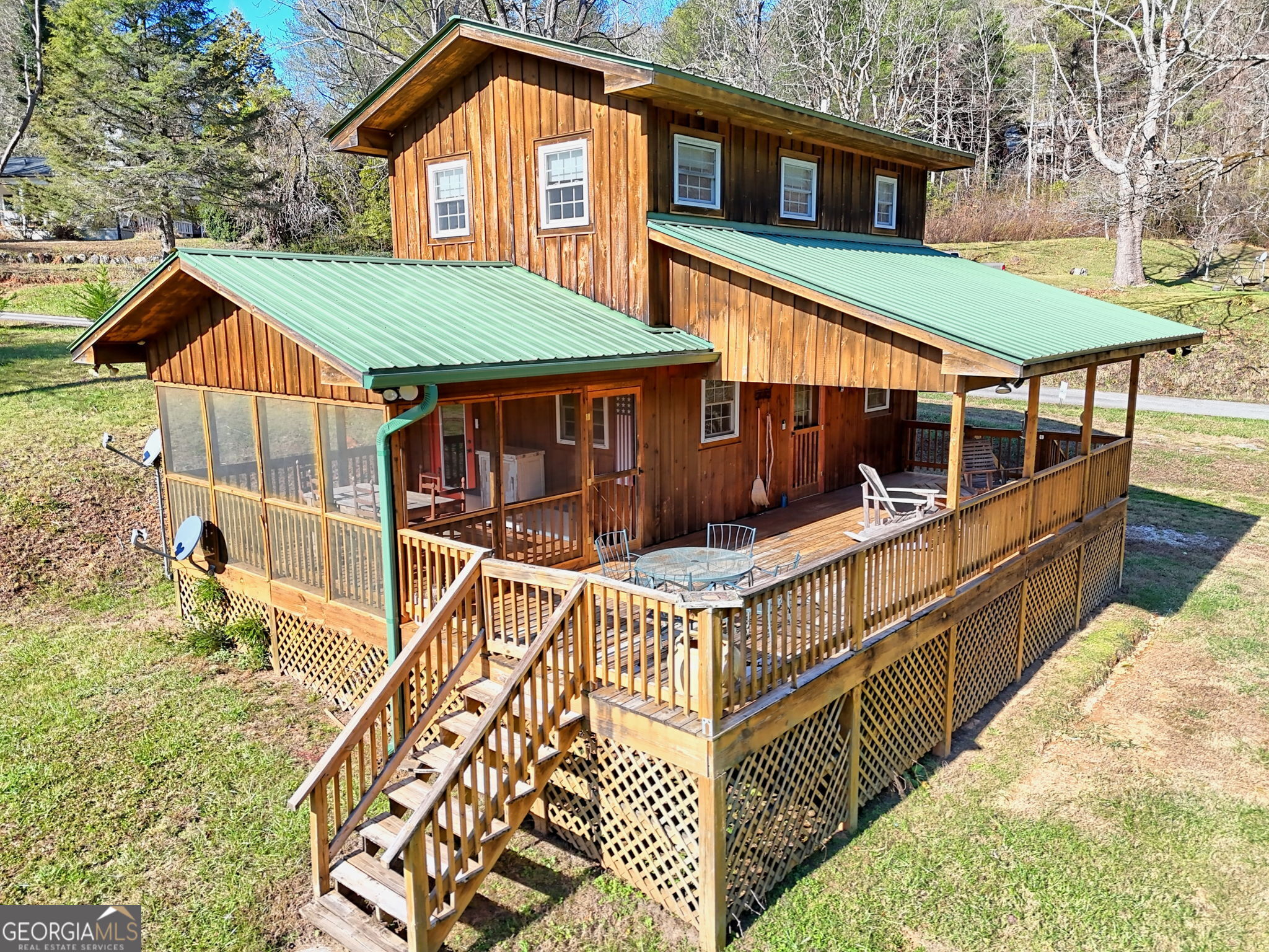 aerial view of a house with large windows and wooden fence