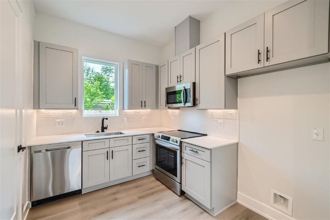 a kitchen with a sink stove and cabinets