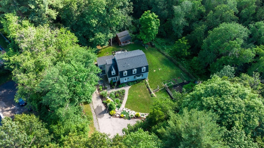 an aerial view of a house with a garden and trees