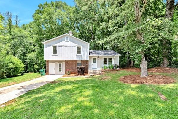 a front view of a house with a yard and trees