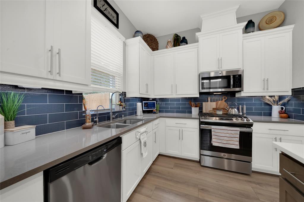 a kitchen with stainless steel appliances granite countertop a sink a stove and a microwave