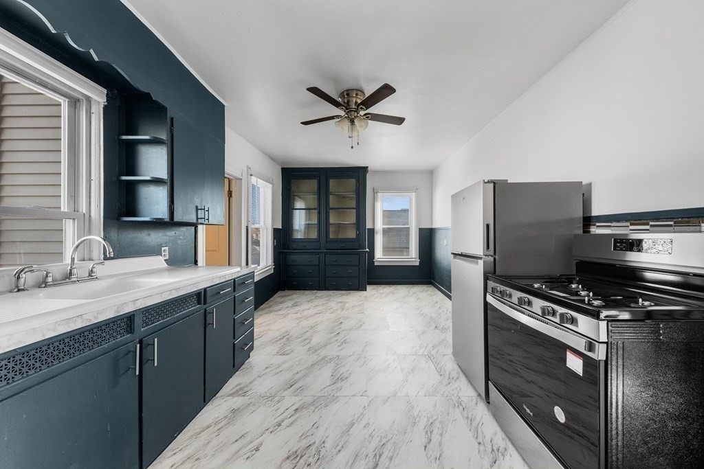 a kitchen with stainless steel appliances a sink cabinets and wooden floor