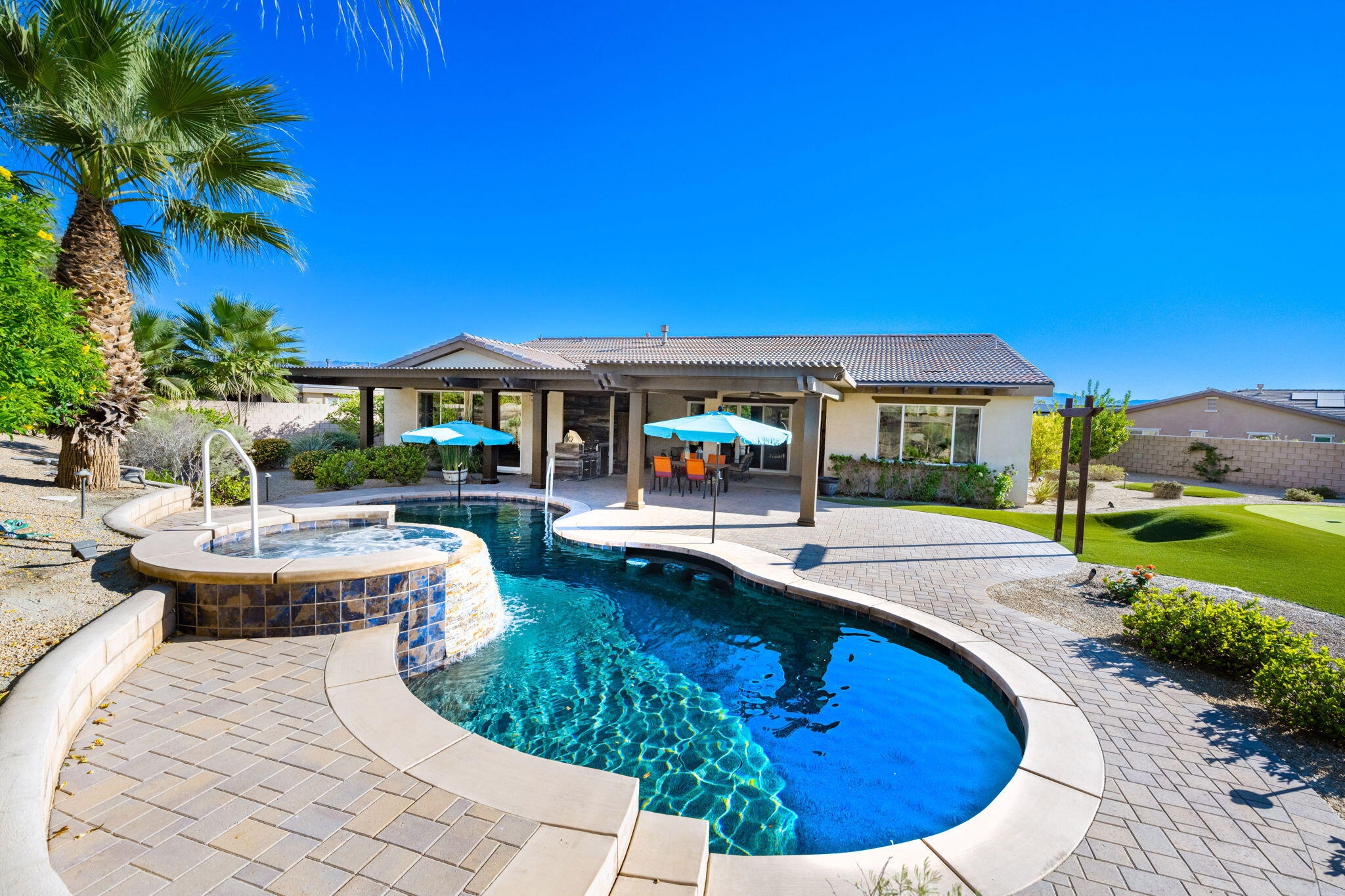 a view of a house with swimming pool and sitting area