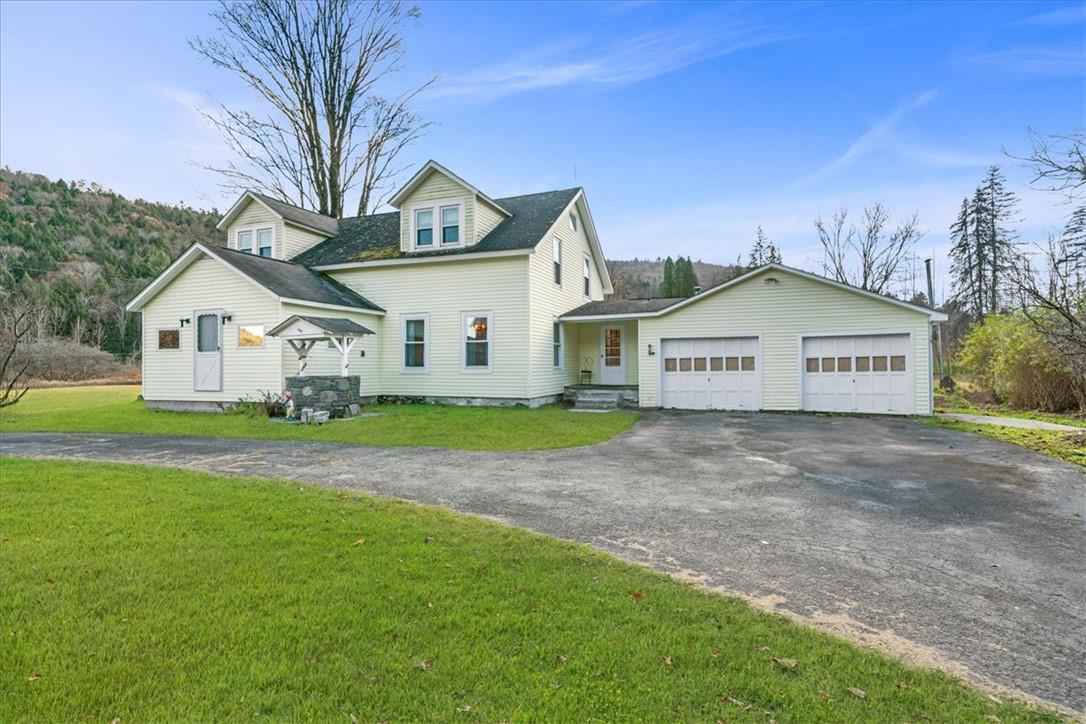 New england style home with a front lawn and a garage