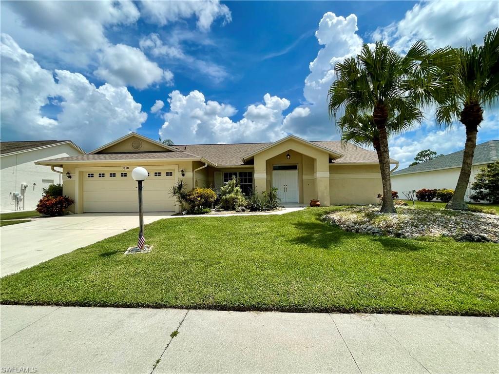 Ranch-style home with a garage and a front yard