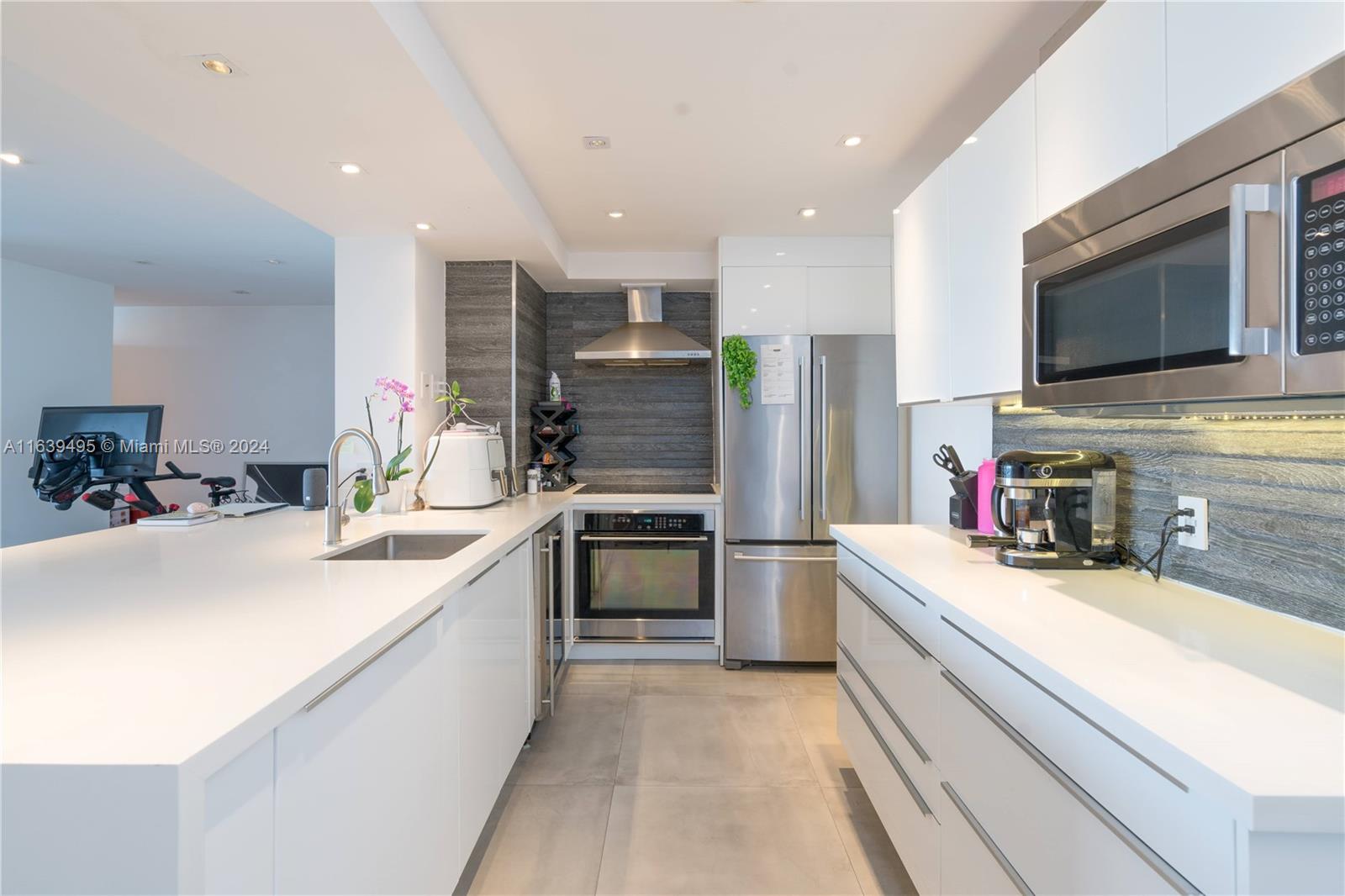 a large kitchen with stainless steel appliances lots of counter space and a sink