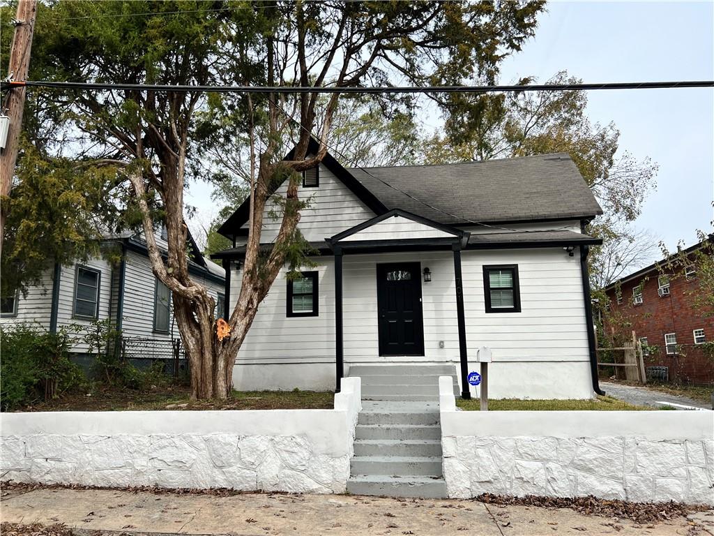 a front view of a house with a tree