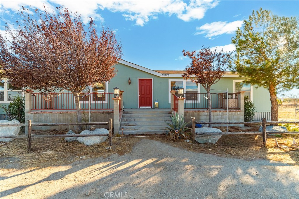 a view of a blue house with yard in front of it