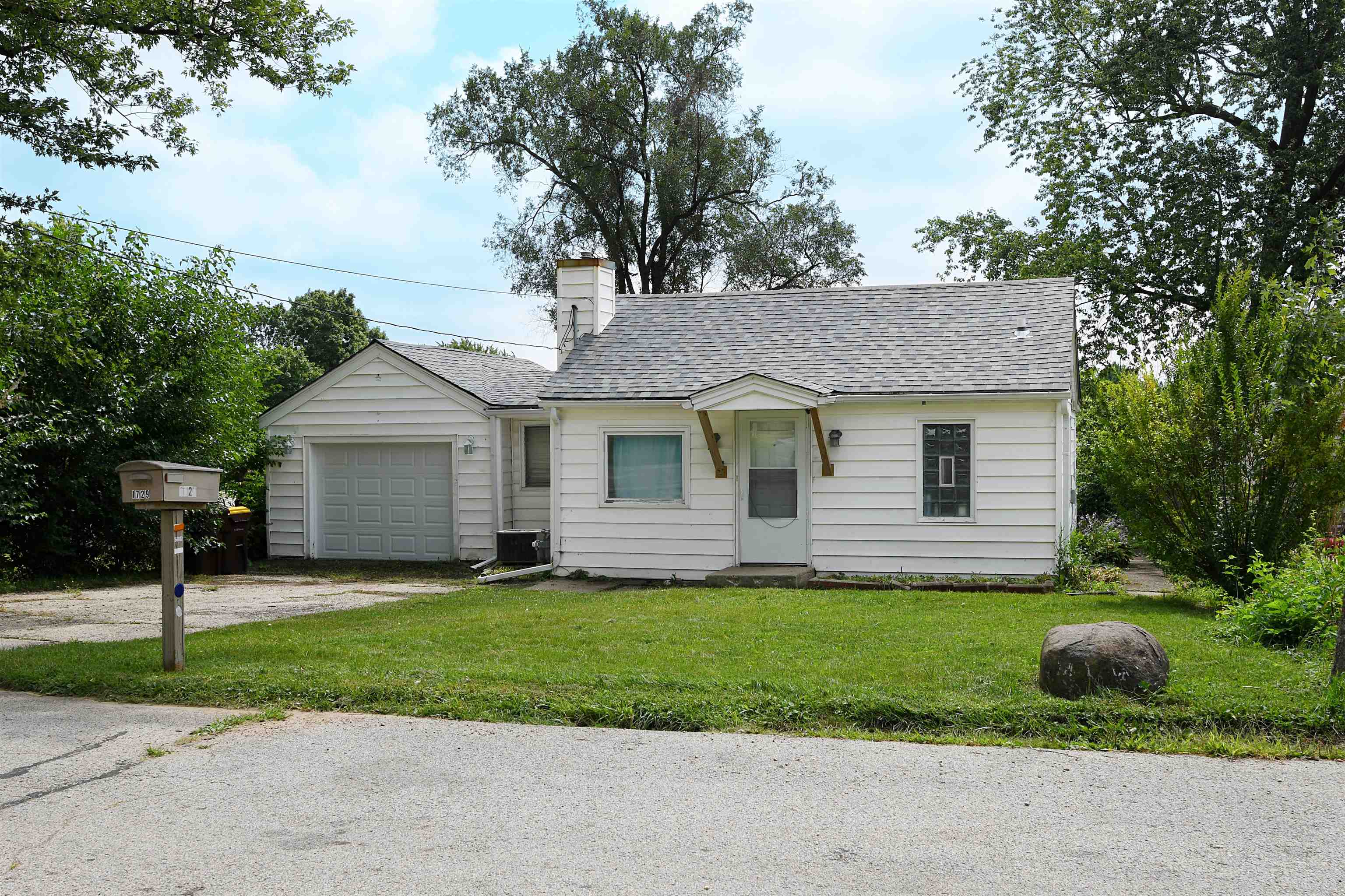 a front view of a house with a garden and yard