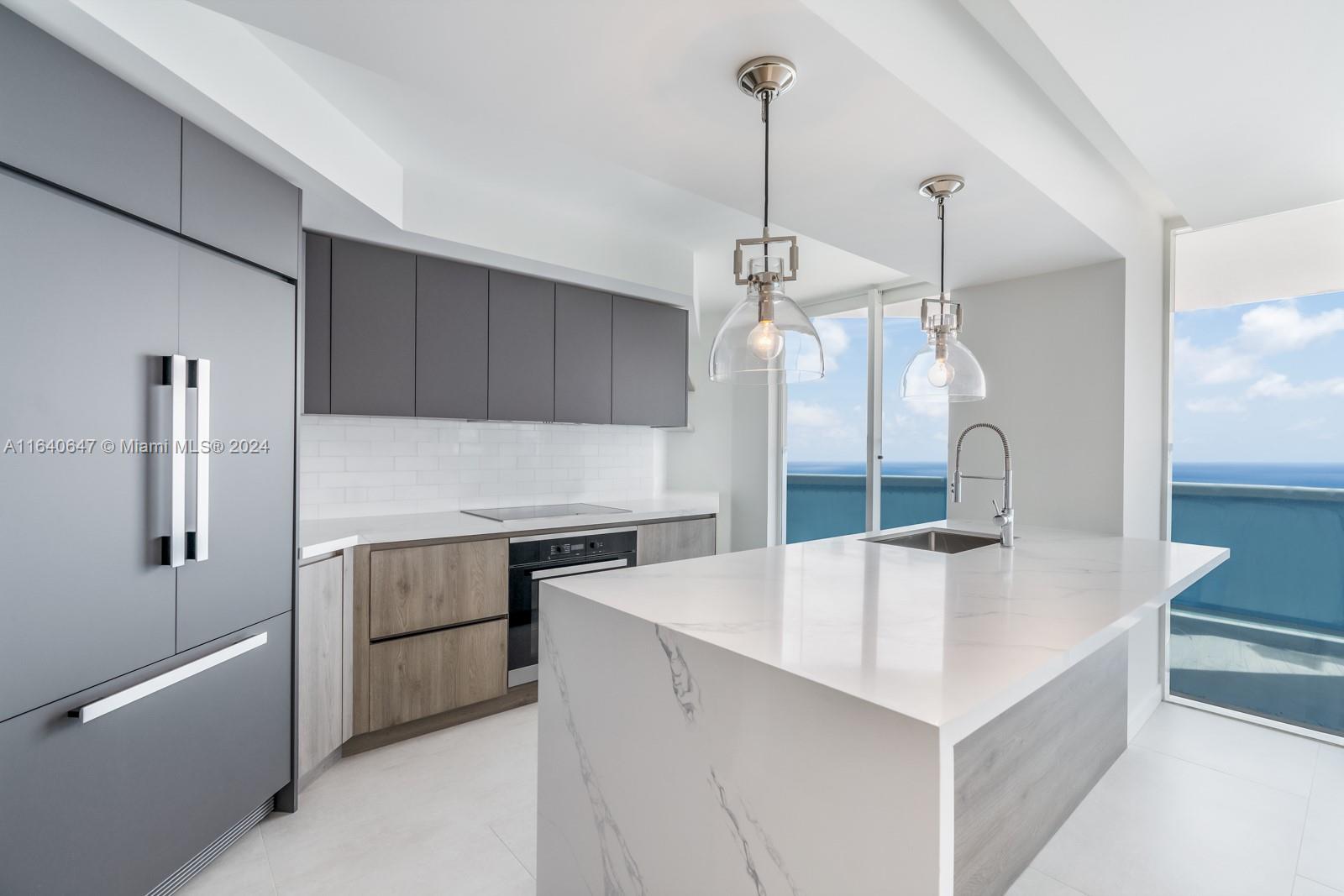 a kitchen with a sink a center island a stove and a wooden floor