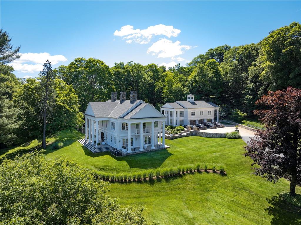 a view of a house with a big yard and large trees